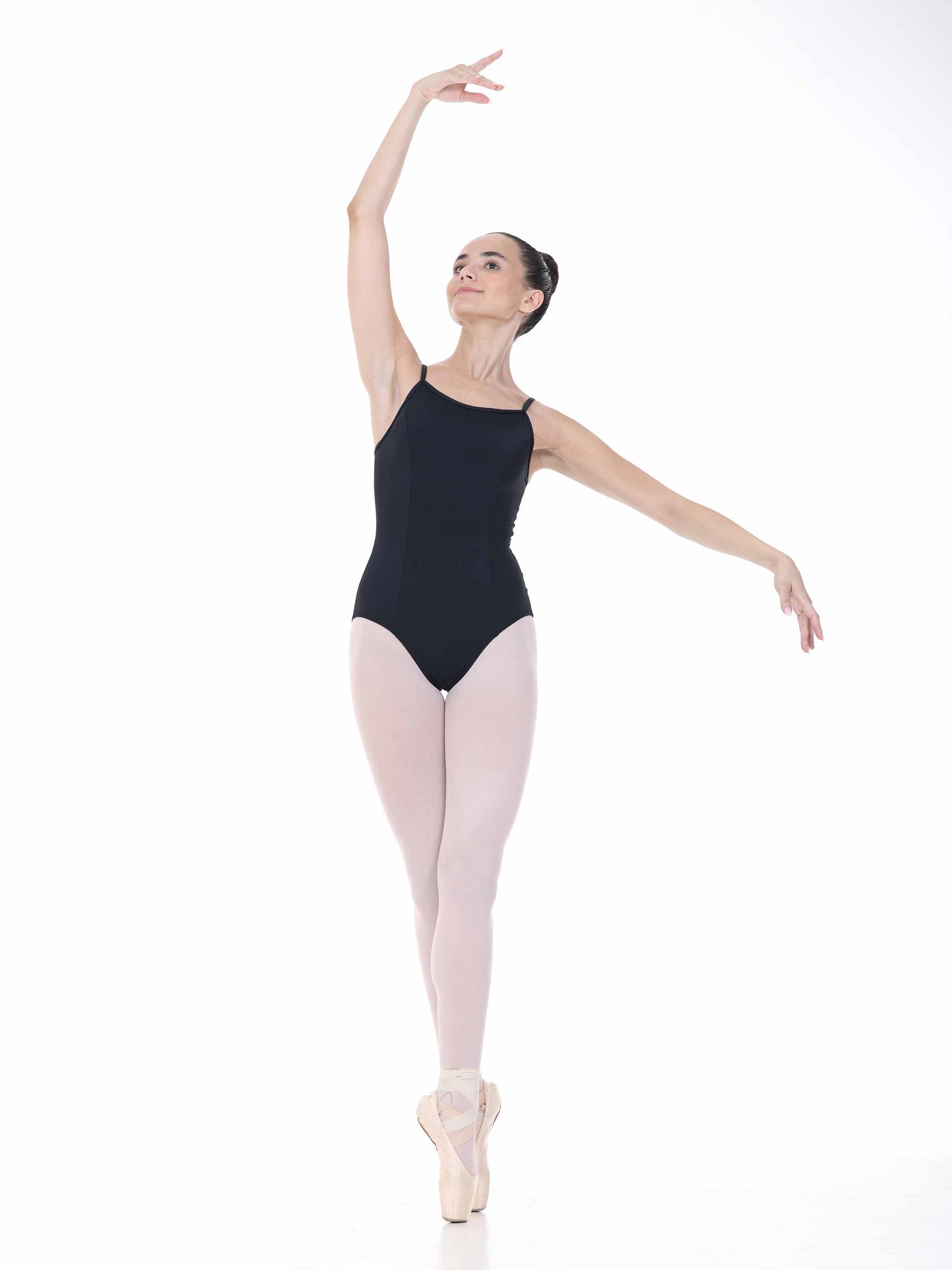 Ballerina in a black leotard and pink tights posing on a white background
