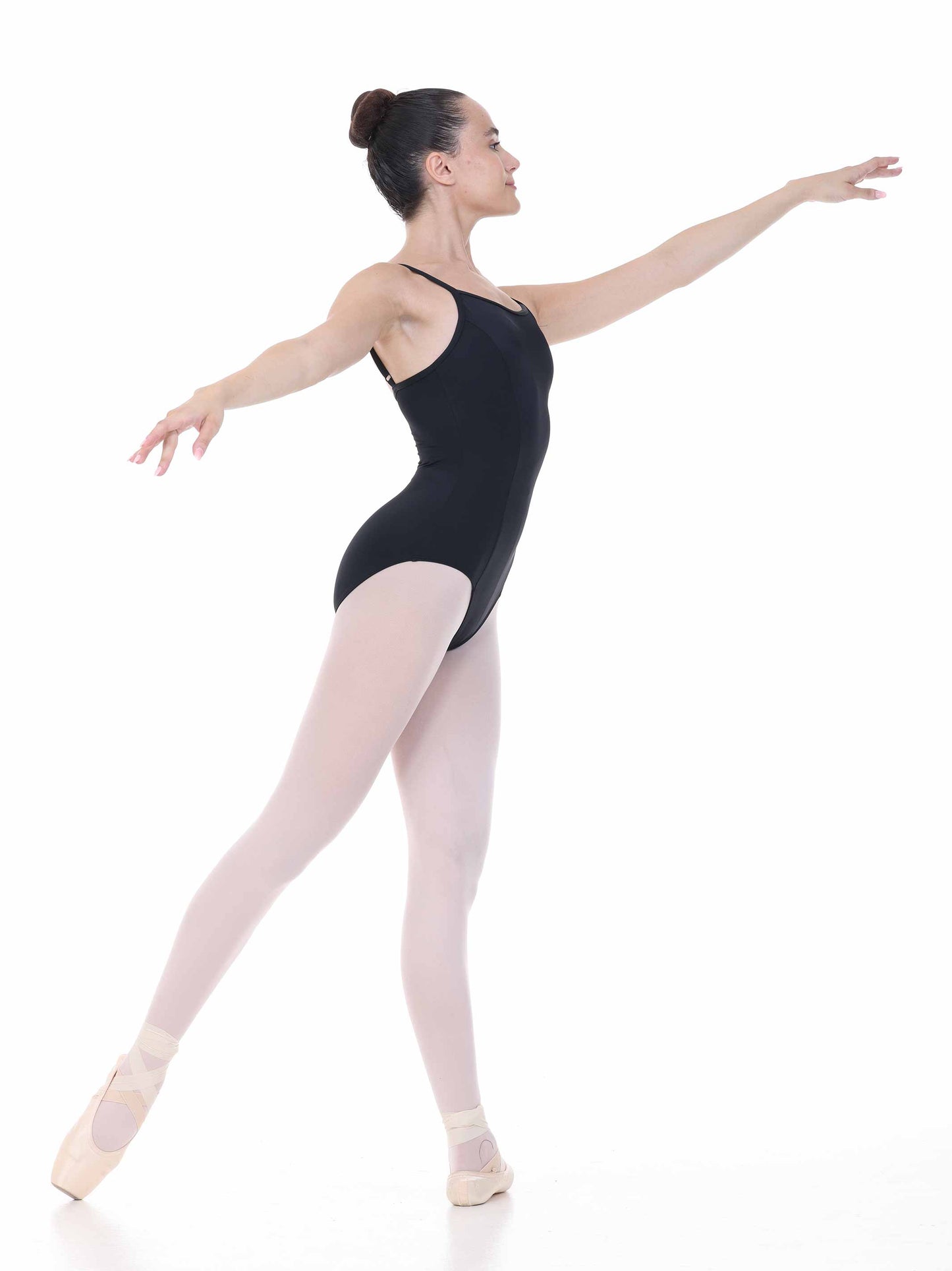Ballerina in a black leotard and pink tights posing on a white background