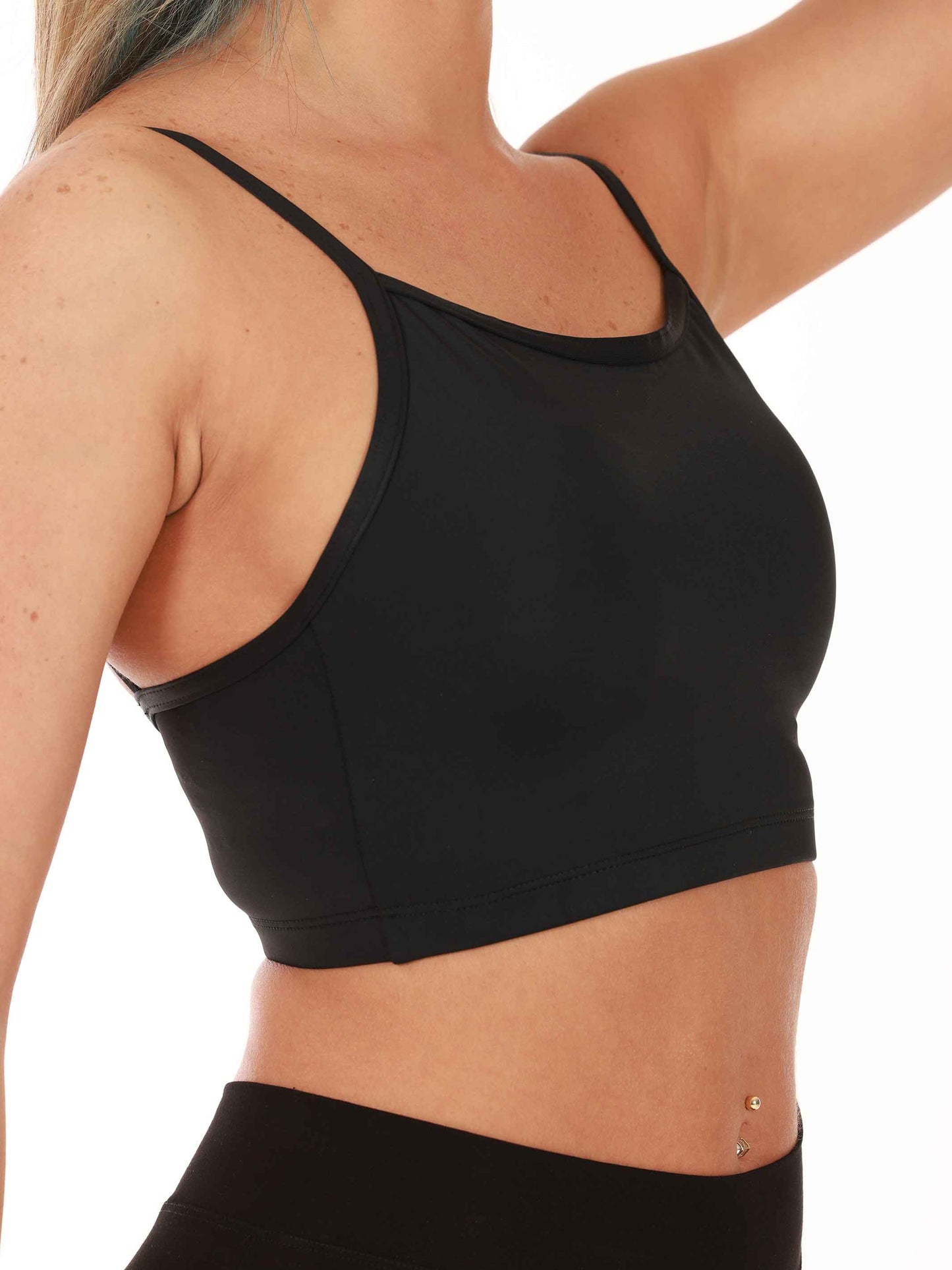 Black sports bra worn by a person on a white background