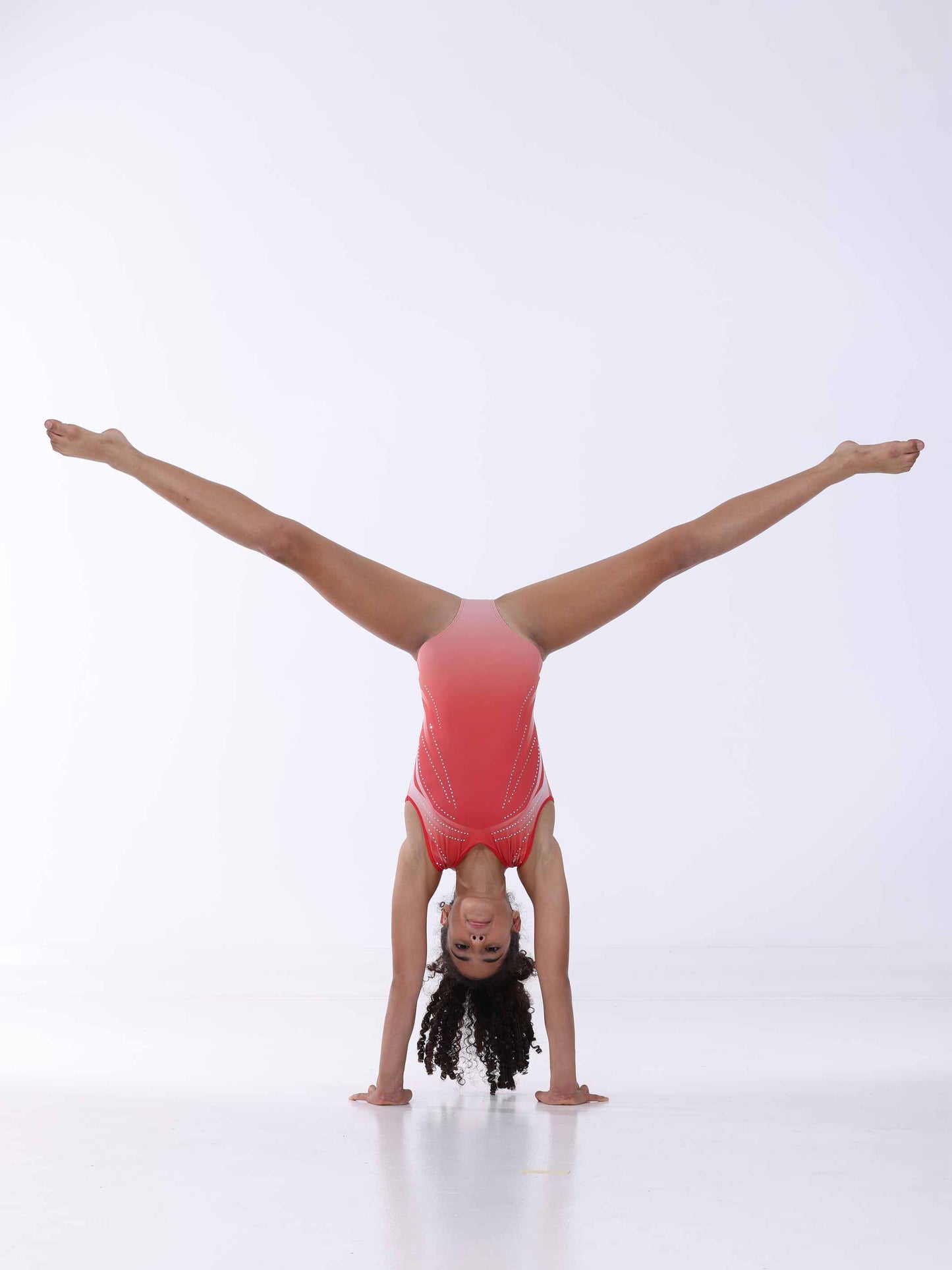 Gymnast performing a handstand on a white background