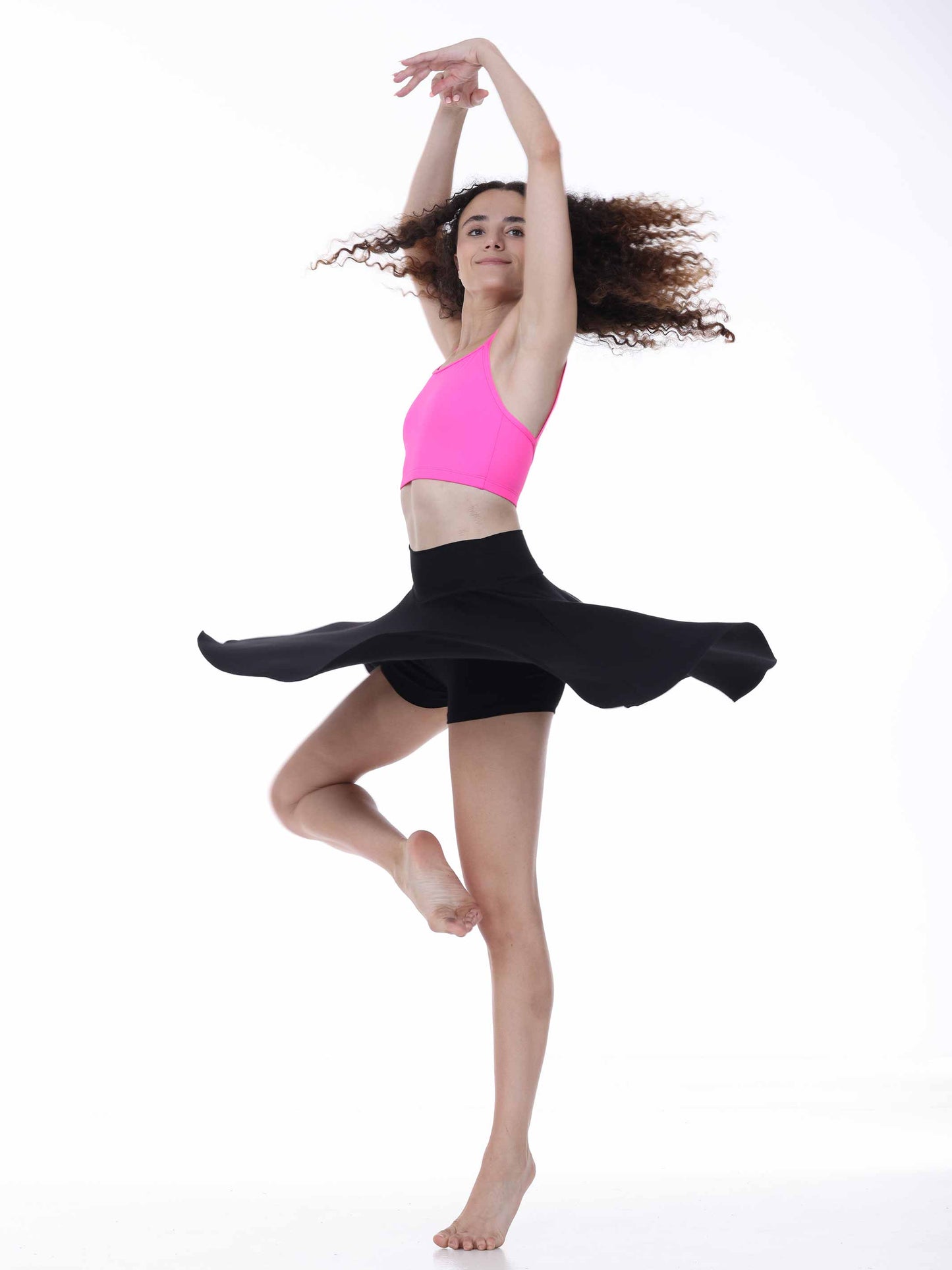 Dancer in a pink top and black skirt on a white background