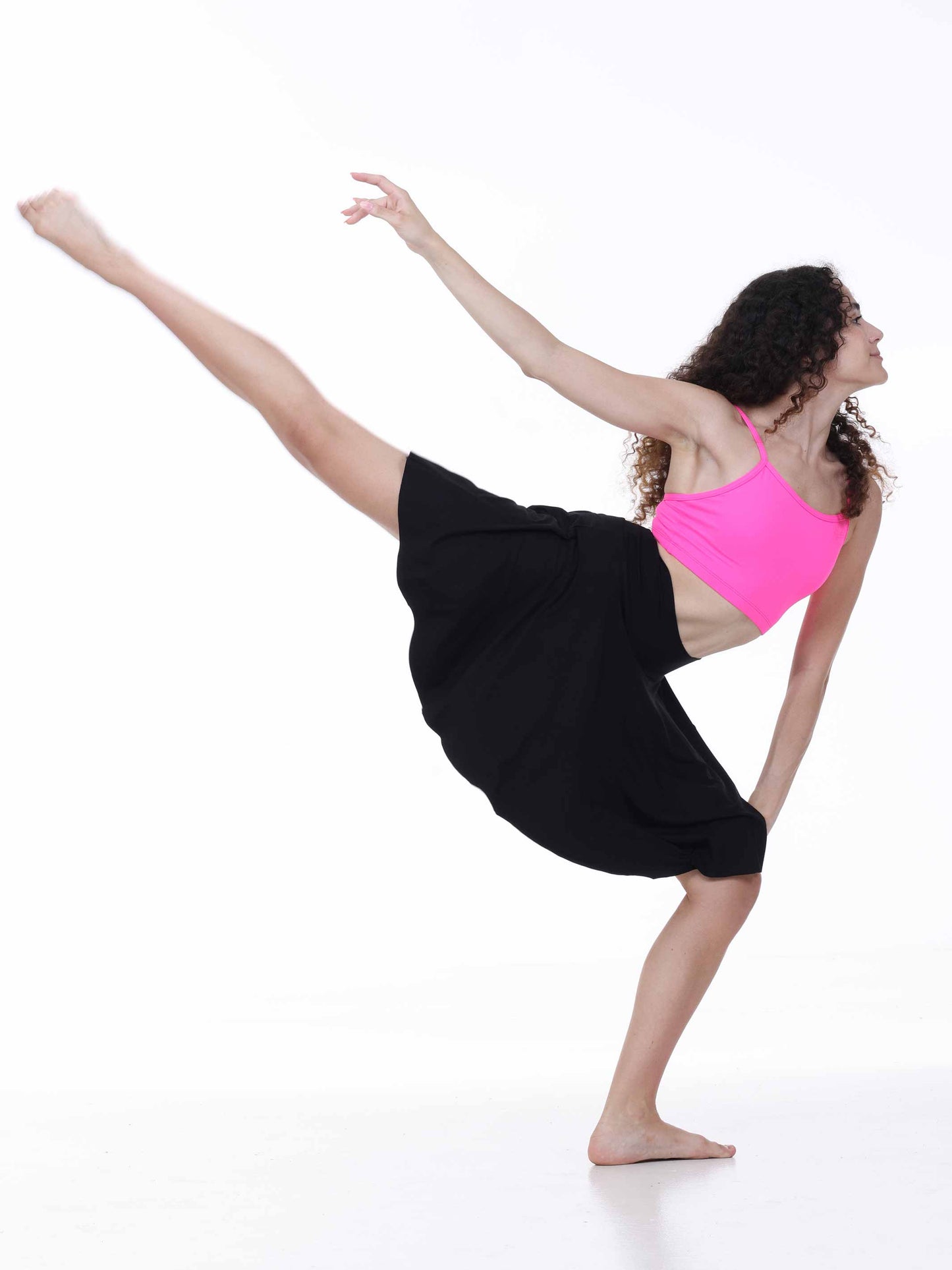 Dancer in a black skirt and pink top on a white background