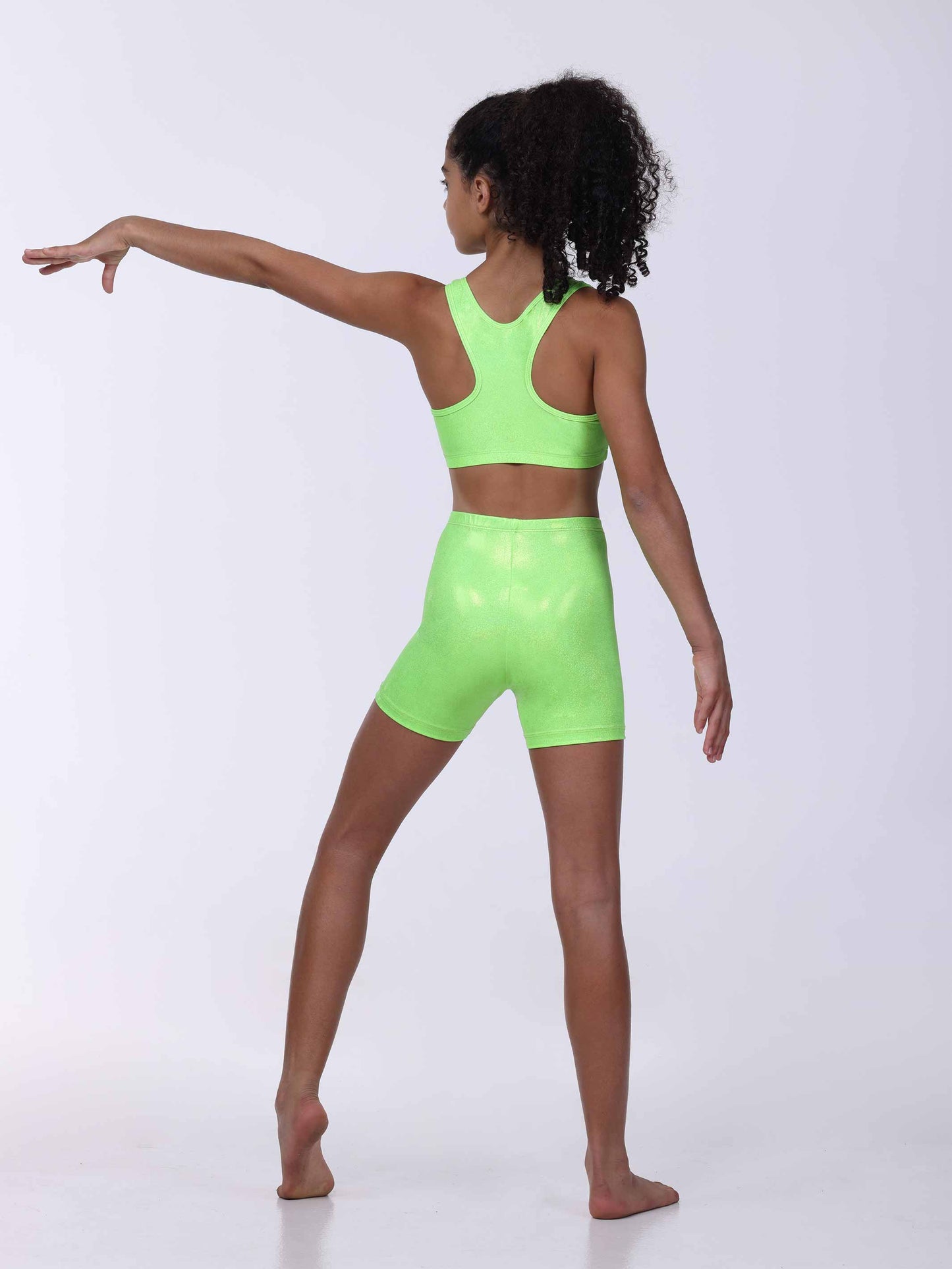 Person wearing a neon green sports bra and shorts set on a white background
