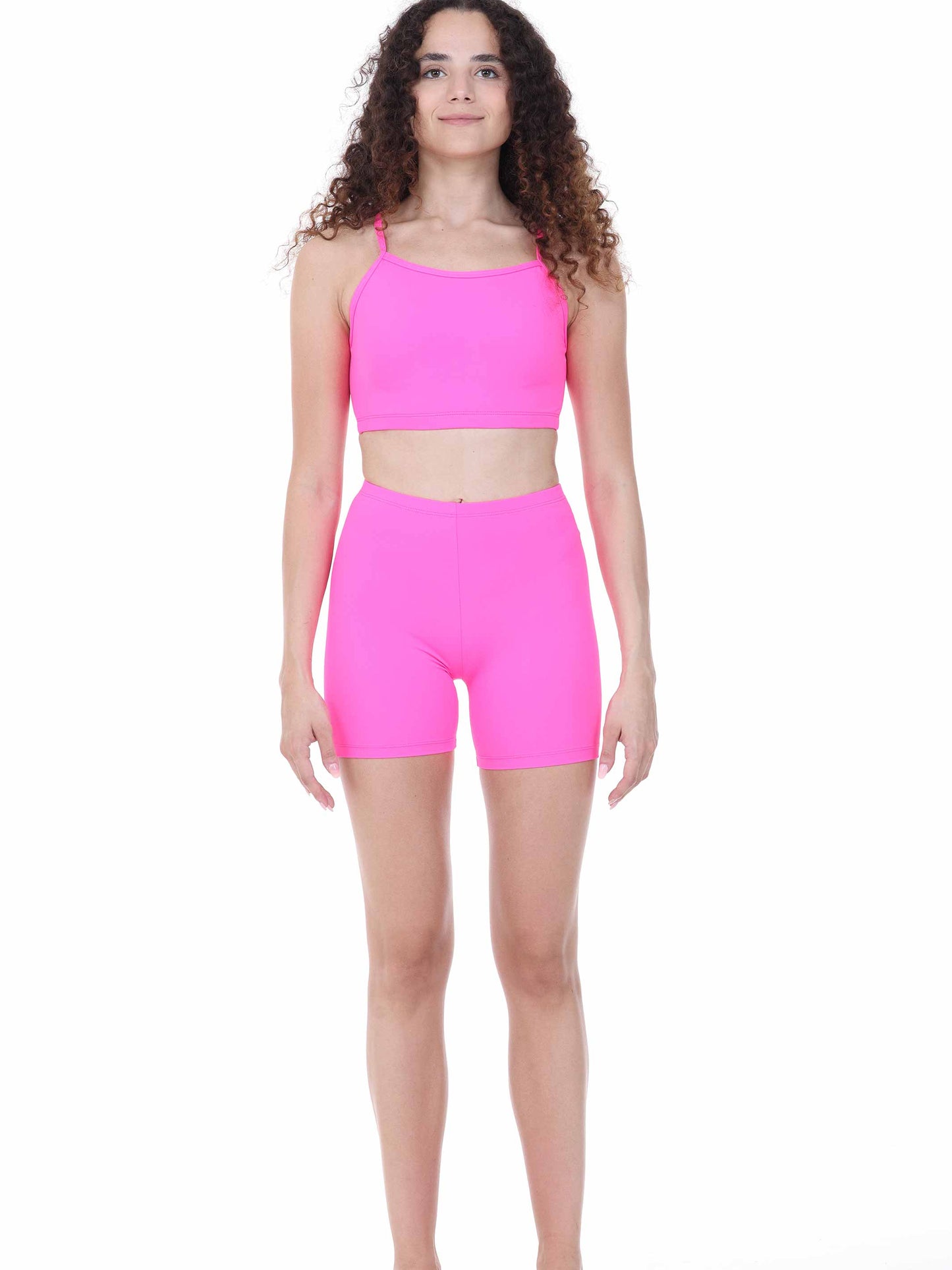 Woman wearing a bright fuchsia athletic outfit on a white background