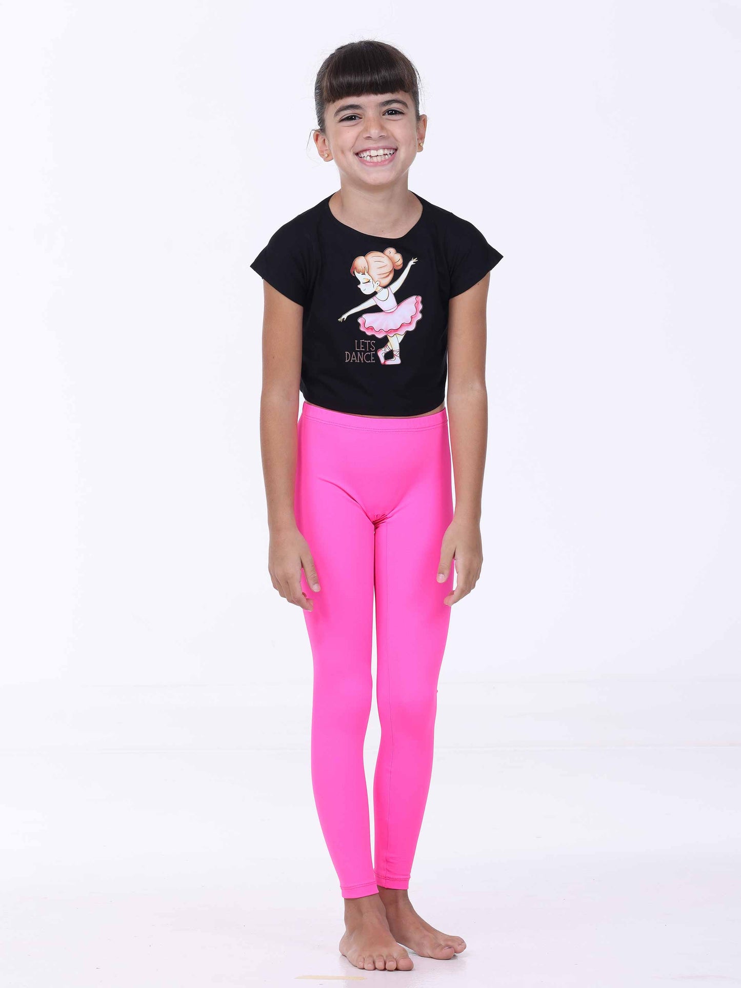 Child wearing a black t-shirt with a ballerina design and pink leggings on a white background