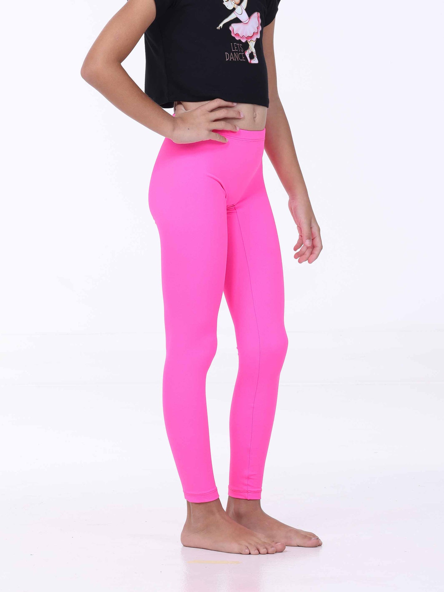 Person wearing bright pink leggings and a black crop top with a graphic design on a white background