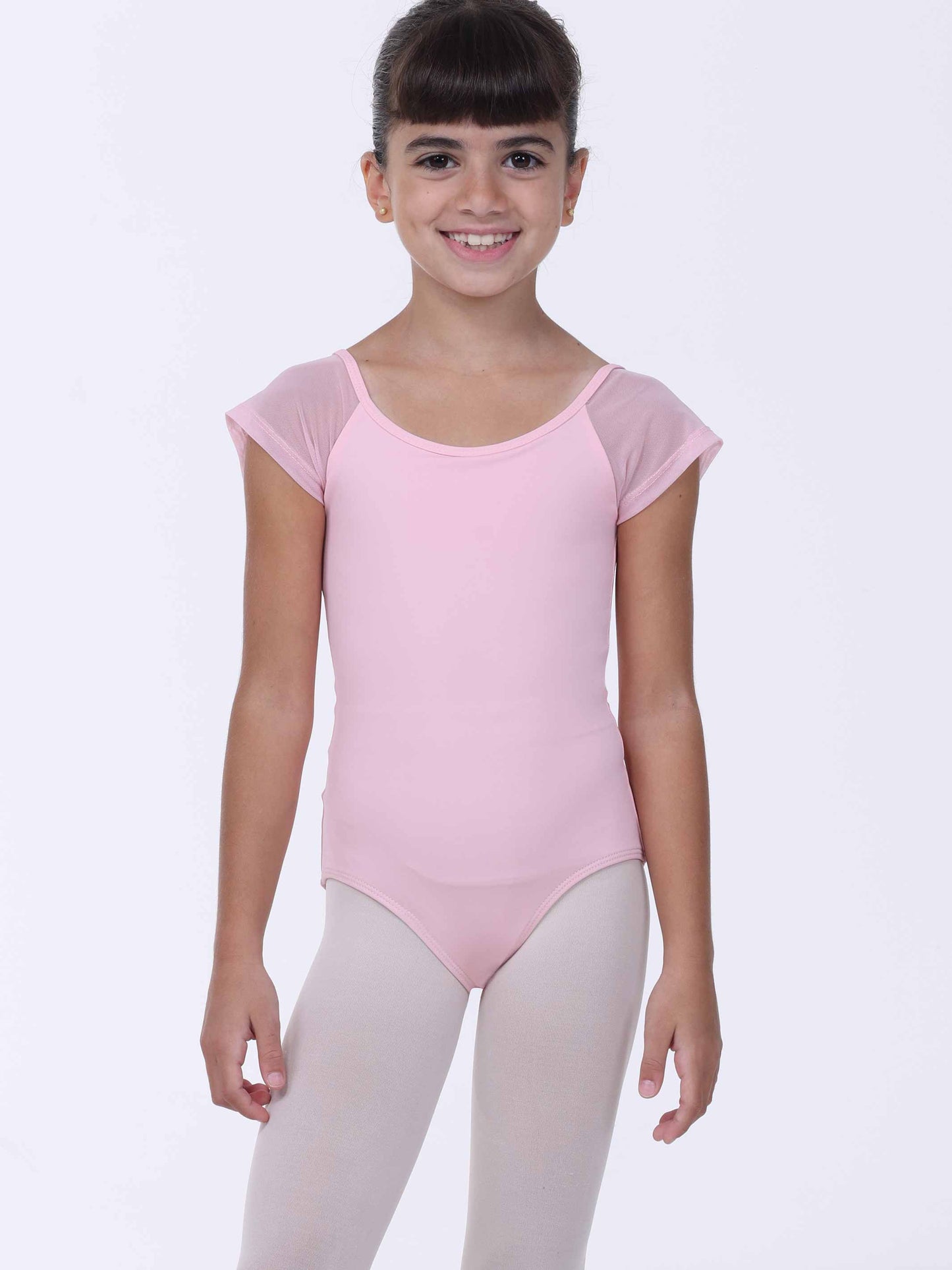 Young girl wearing a pink ballet leotard with sheer sleeves on a white background