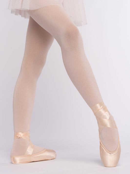 Ballerina wearing pointe shoes and a tutu on a plain background