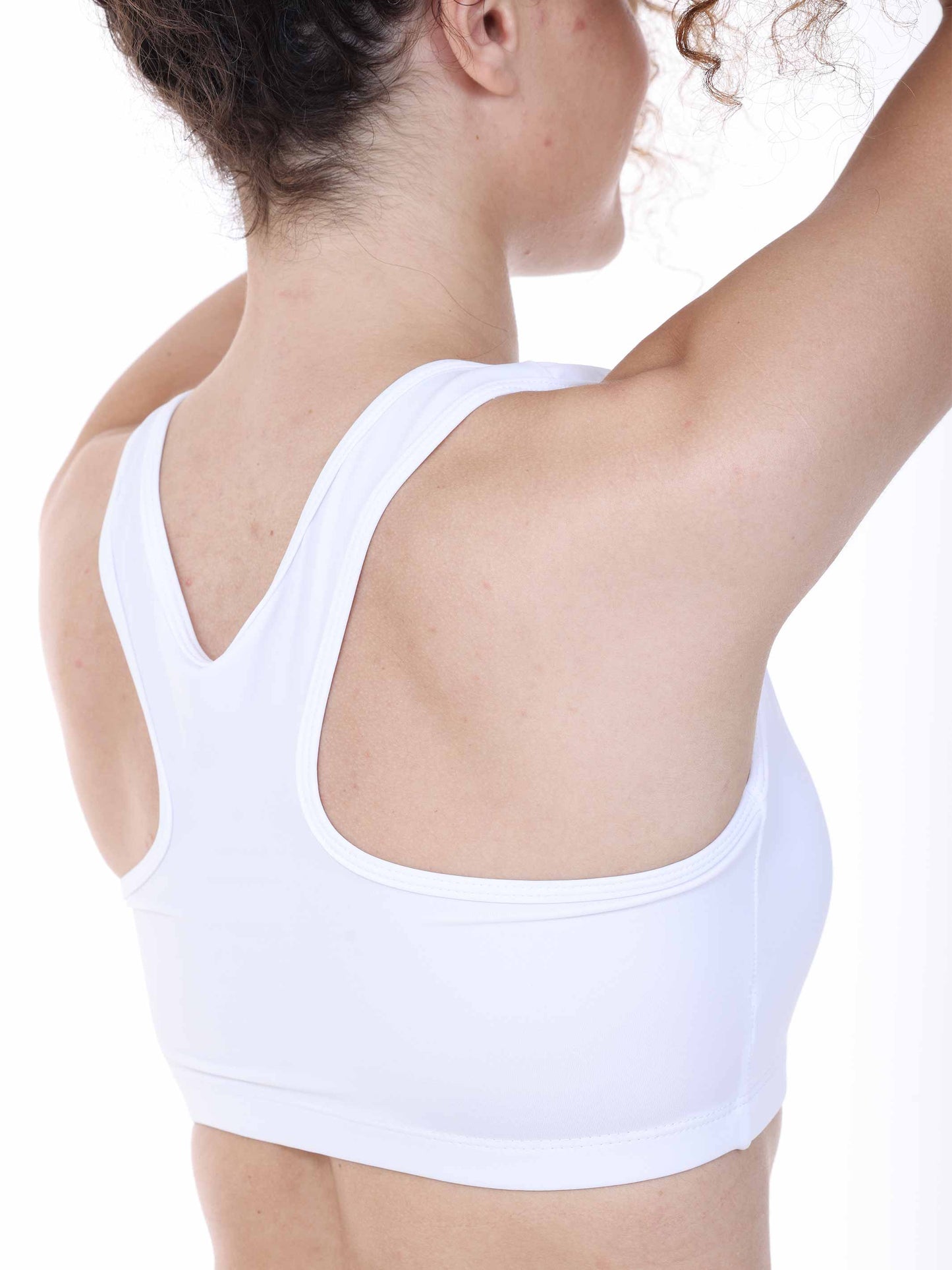 White sports bra worn by a person on a white background