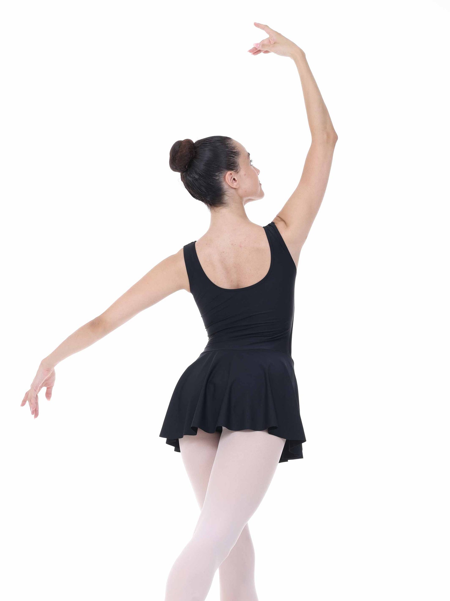 Ballerina in a black leotard and pink tights posing on a white background