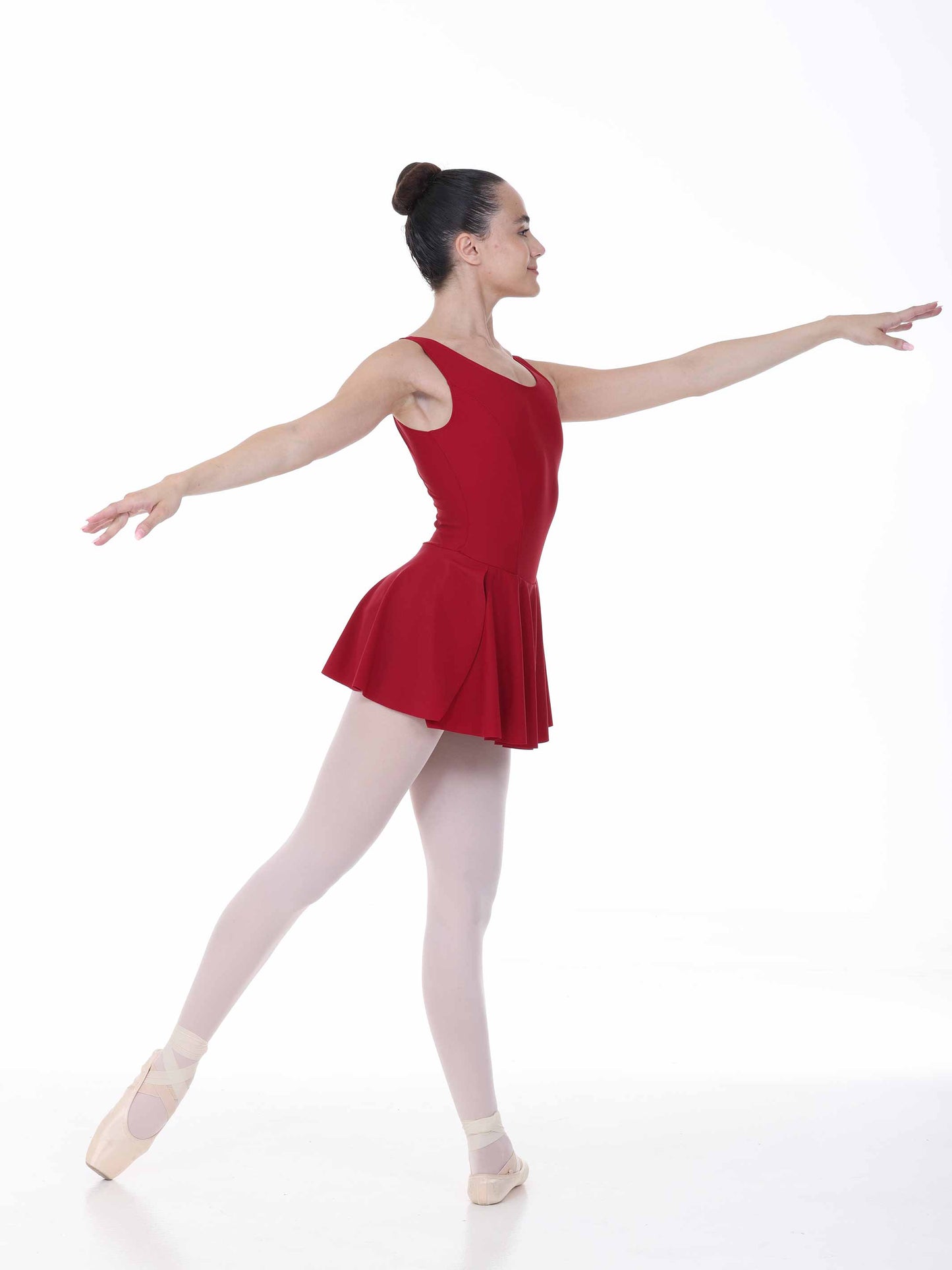 Ballerina in a red dress posing on a white background