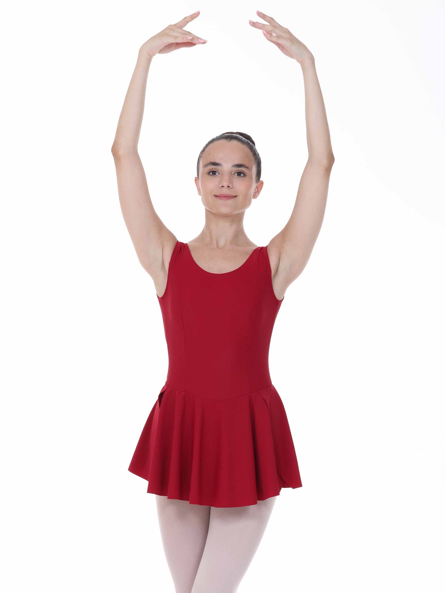 Ballerina in a burgundy dress and white tights posing on a white background