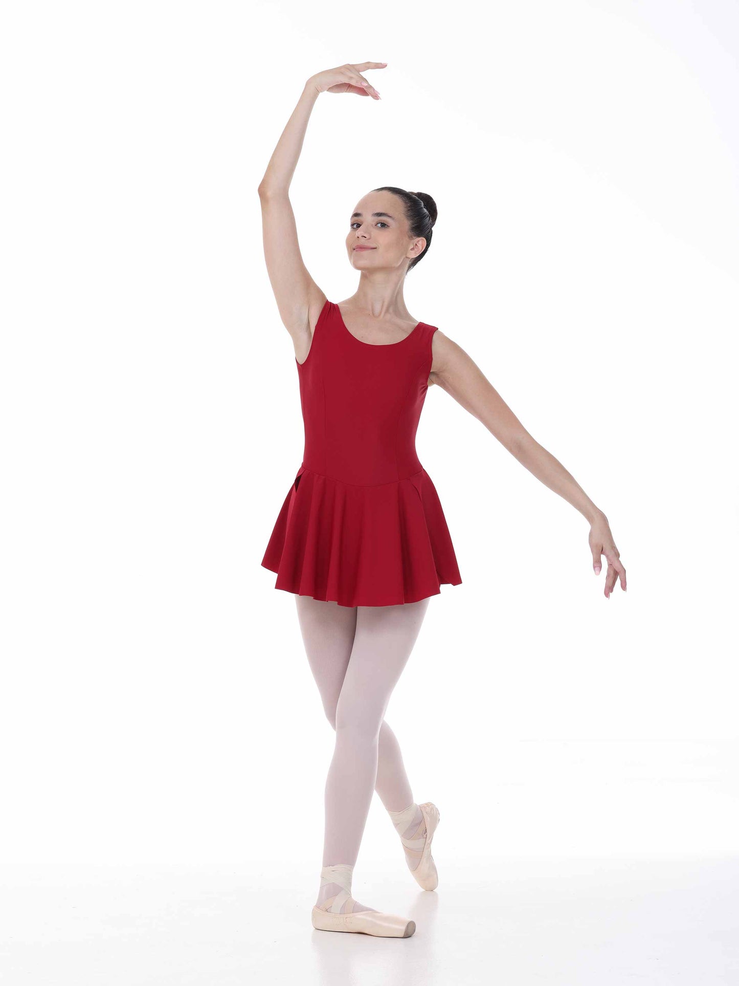 Ballerina in a burgundy dress and white tights posing on a white background