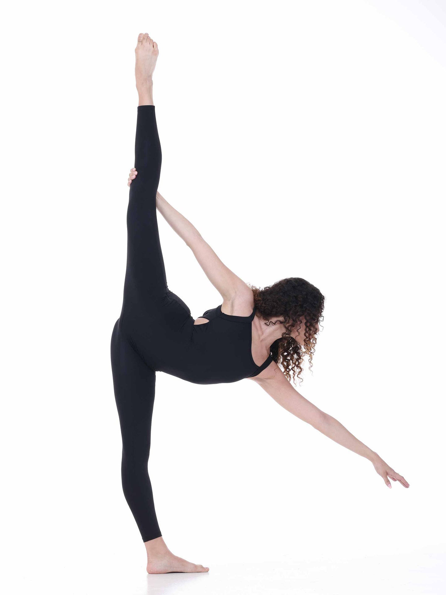 Person in a black outfit performing a yoga pose on a white background