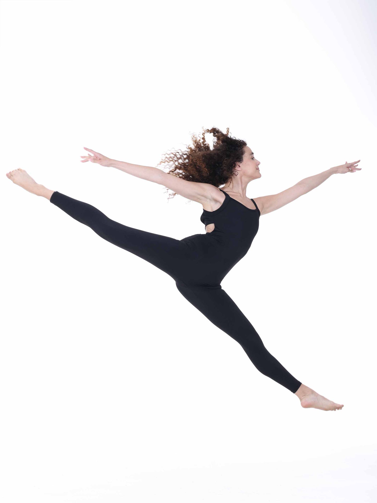 Dancer in a black outfit performing a split leap on a white background