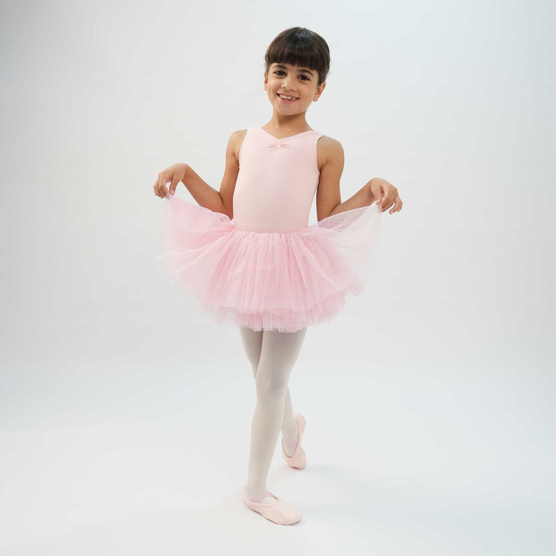 Young ballet dancer wearing a pink leotard tutu dress