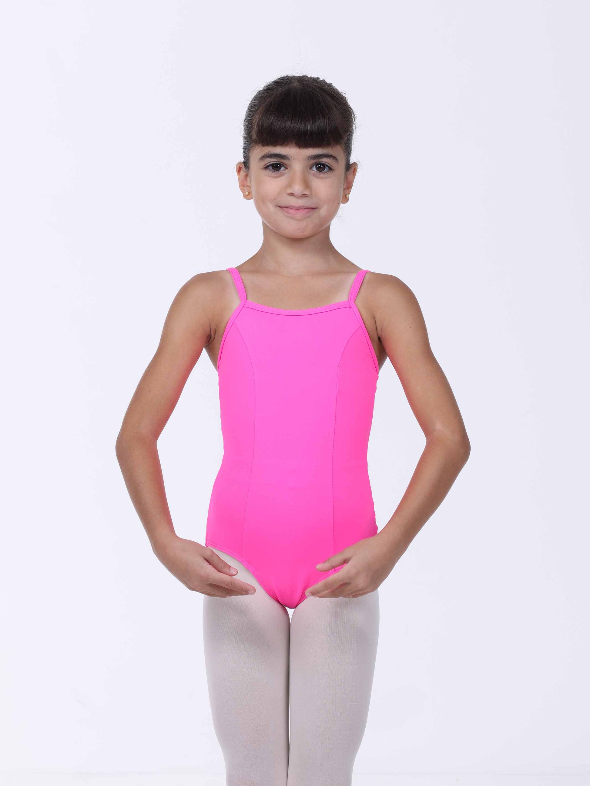 Young girl wearing a bright pink ballet leotard on a white background
