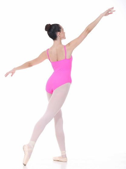 Ballerina in a bright fuchsia leotard and white tights posing on a white background