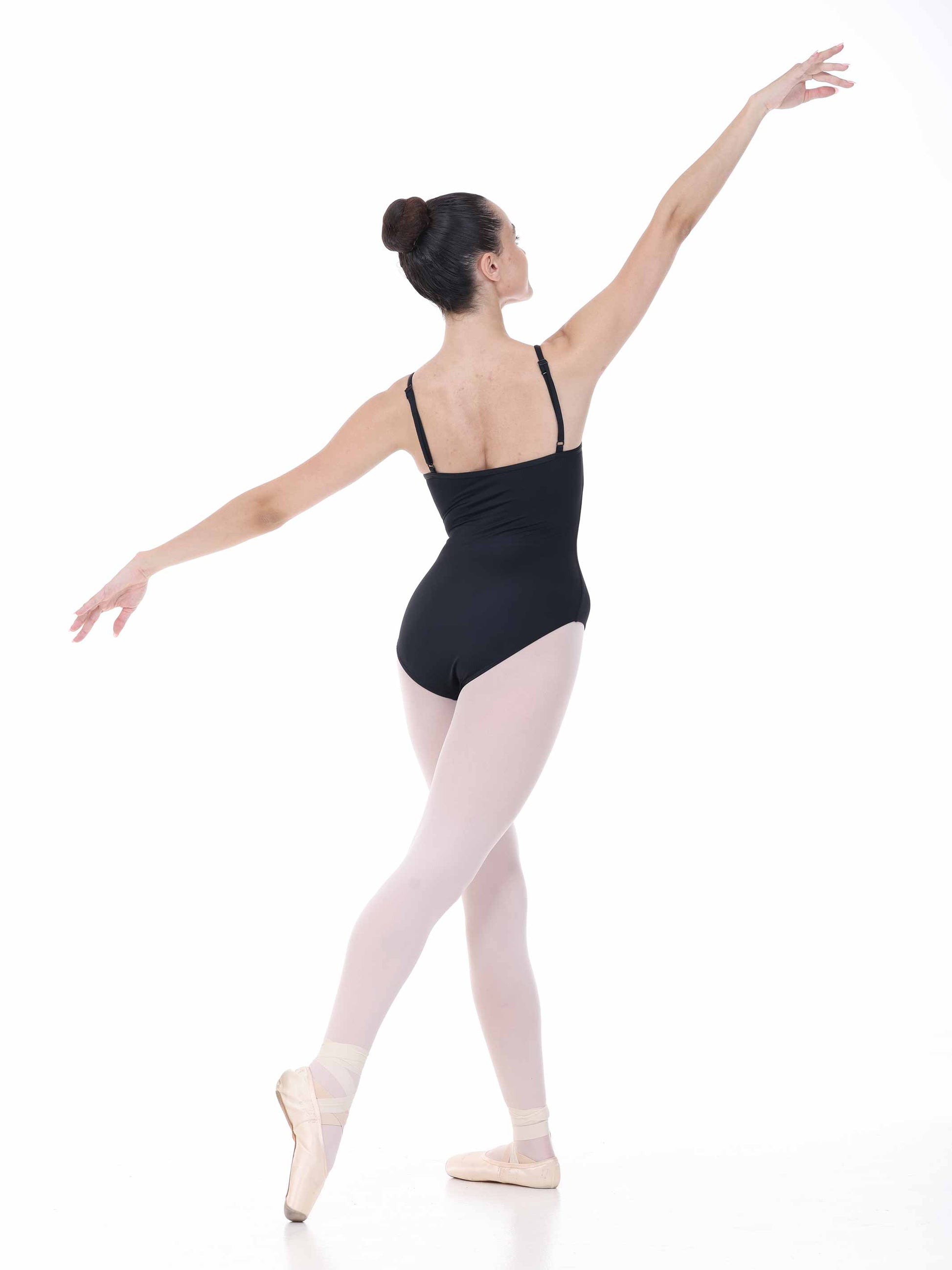 Ballerina in a black leotard and pink tights posing on a white background