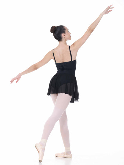 Ballerina in a black dress and pink tights posing on a white background