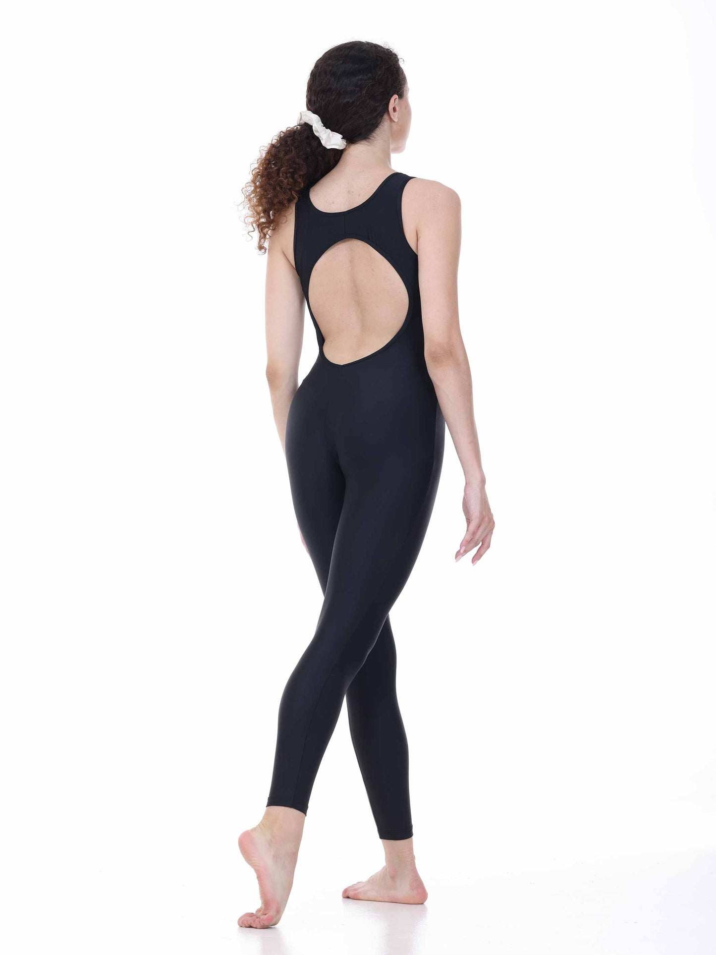 Woman wearing a black open-back bodysuit on a white background
