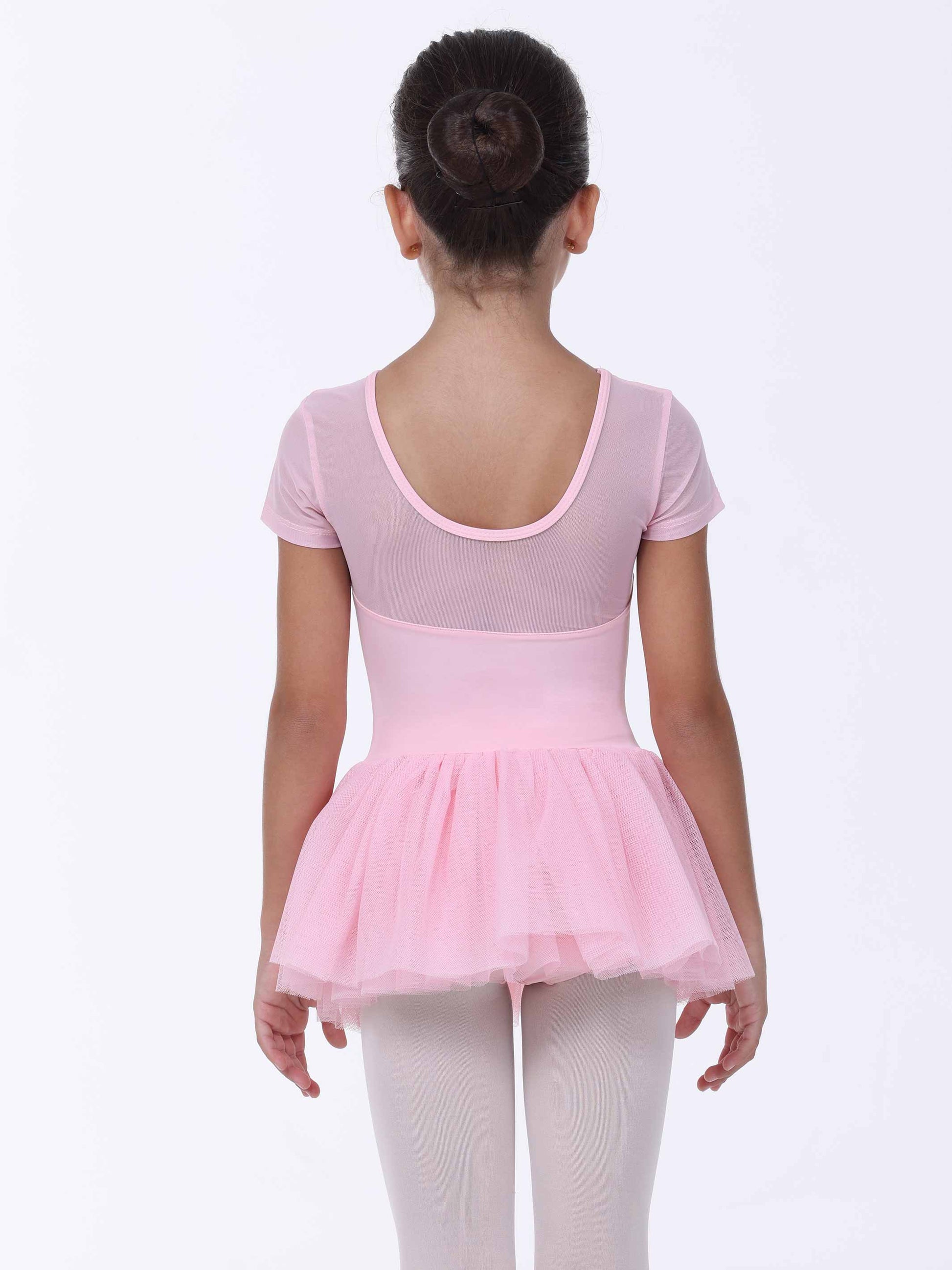 Young girl wearing a pink ballet dress on a white background