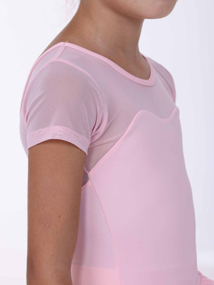 Close-up of a girl wearing a pink ballet dress with a plain background