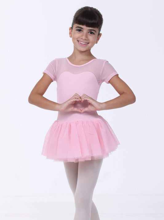 Young girl in a pink ballet outfit making a heart shape with her hands on a white background