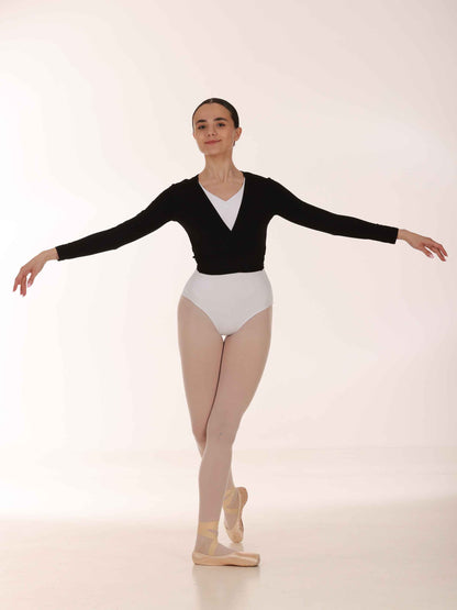 Ballerina in a black long-sleeve warmer top and white leotard posing on a white background