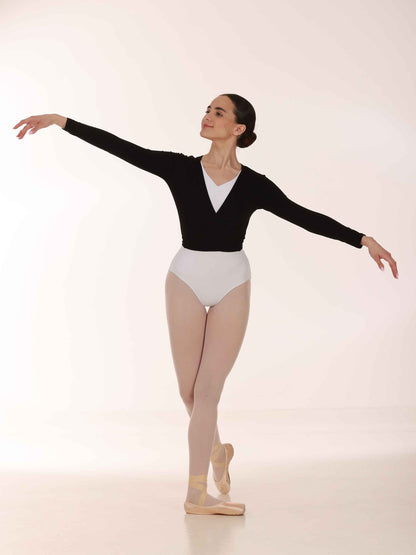 Ballerina in a black long-sleeve warmer crossover and white leotards posing on a light background