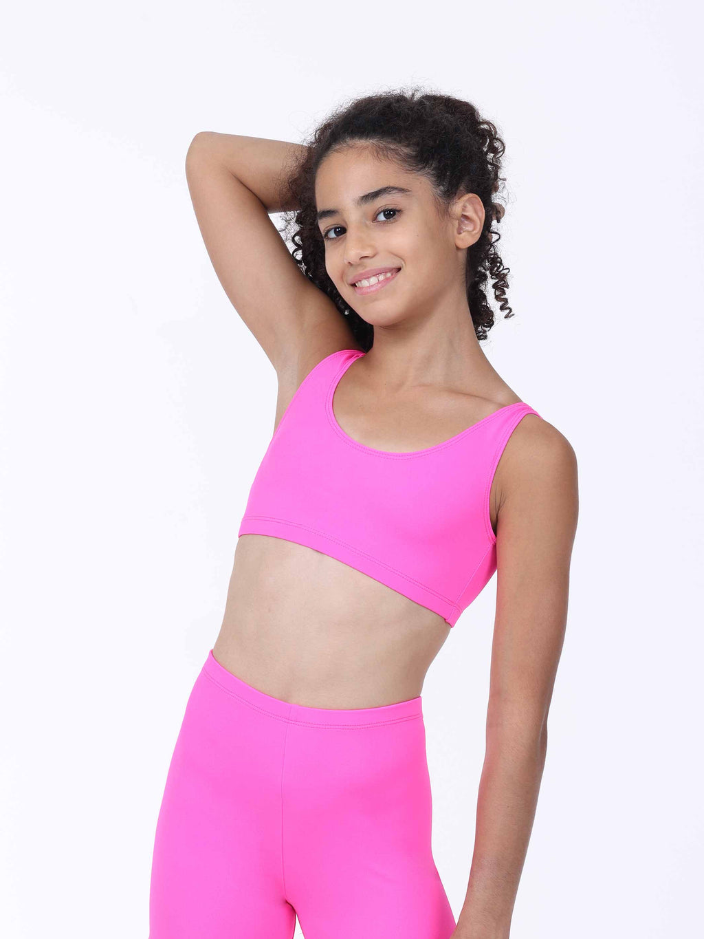 Person wearing a bright pink sports bra and leggings on a white background