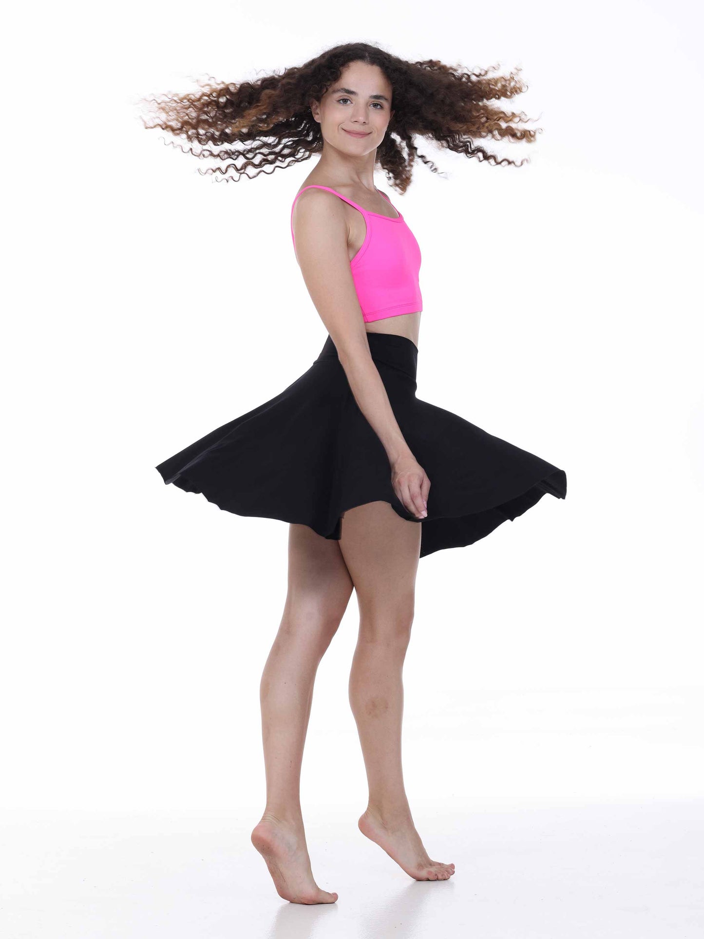 Woman wearing a black skirt and pink top on a white background