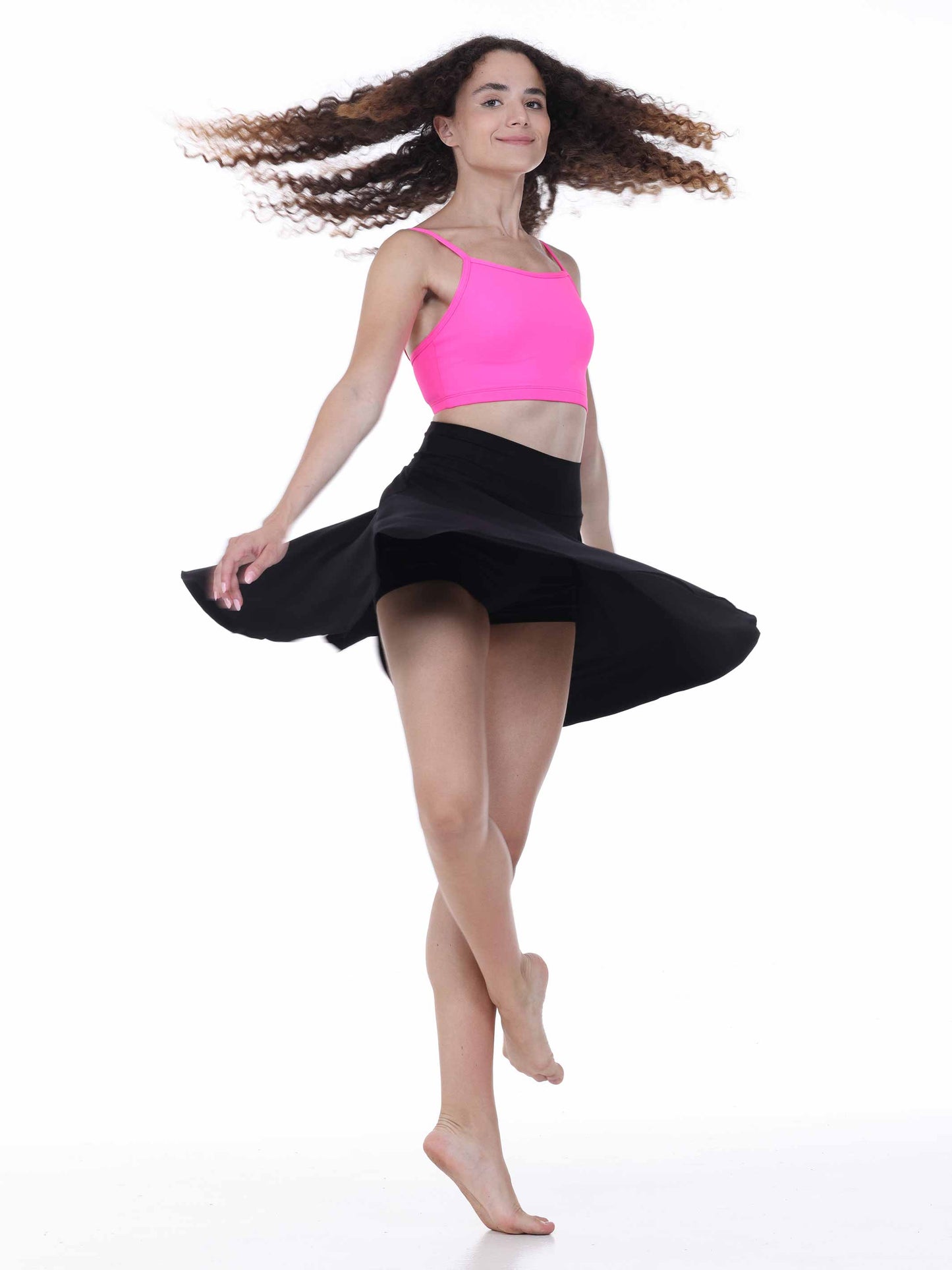 Dancer in a pink top and black skirt on a white background