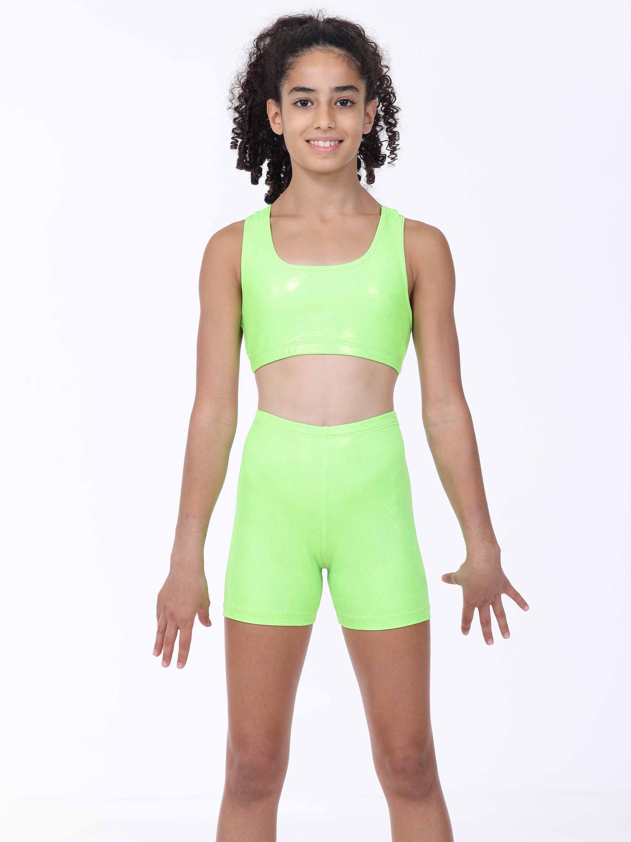 Young girl wearing a bright green athletic gymnastics outfit on a white background