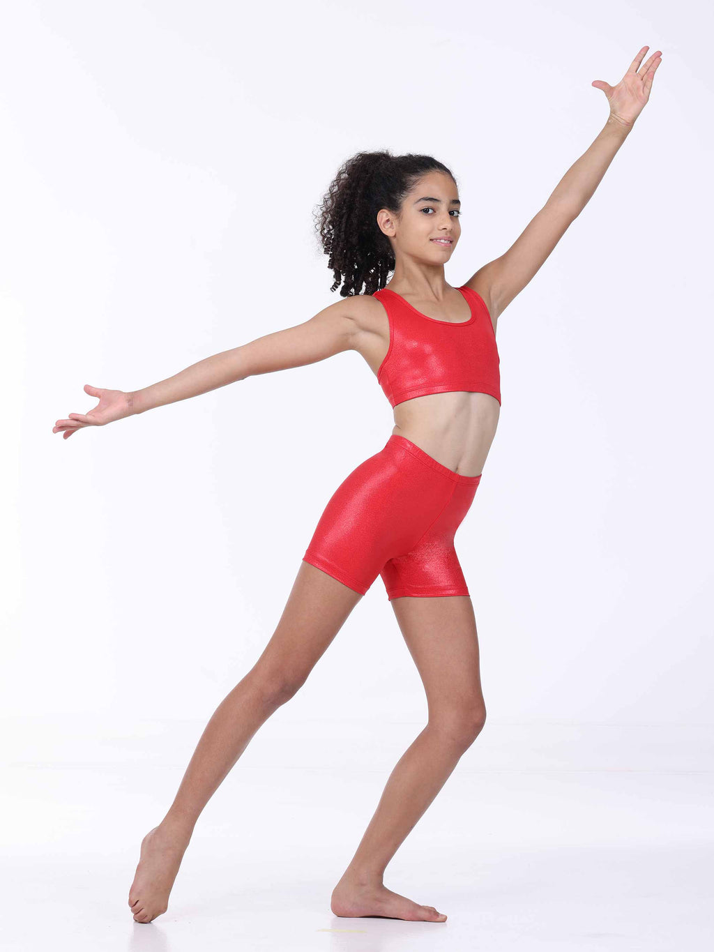 Woman in red athletic gymnastics outfit posing on a white background