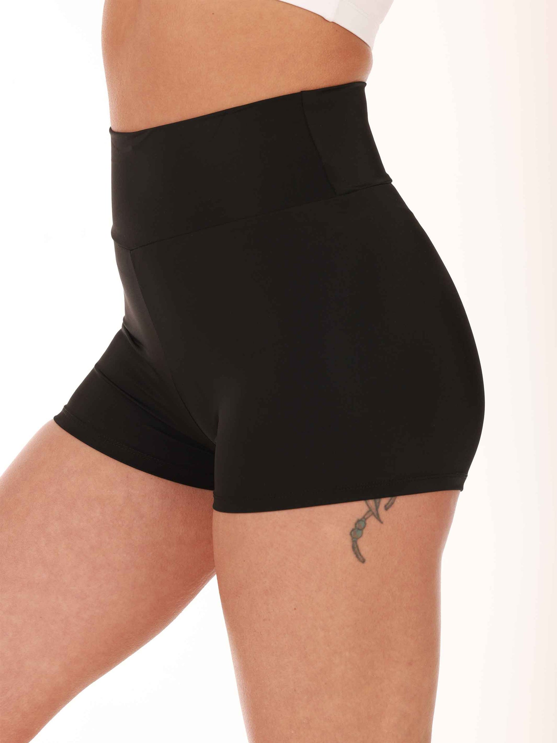 Black high-waisted shorts worn by a person on a white background