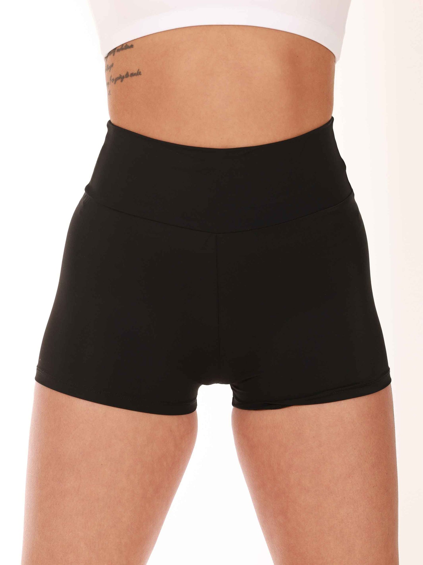 Person wearing black high-waisted shorts on a white background