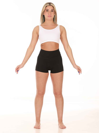 Woman wearing a white sports bra and black shorts on a white background