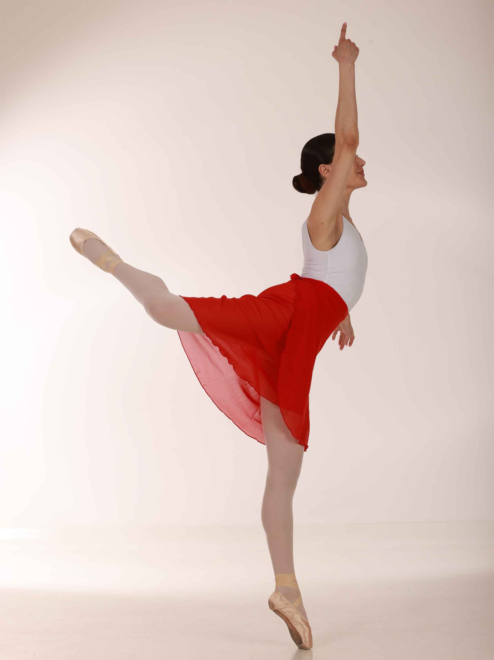 Ballerina posing in a long red chiffon skirt and white top