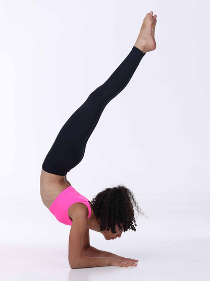 Person performing a yoga pose with one leg extended upwards on a white background