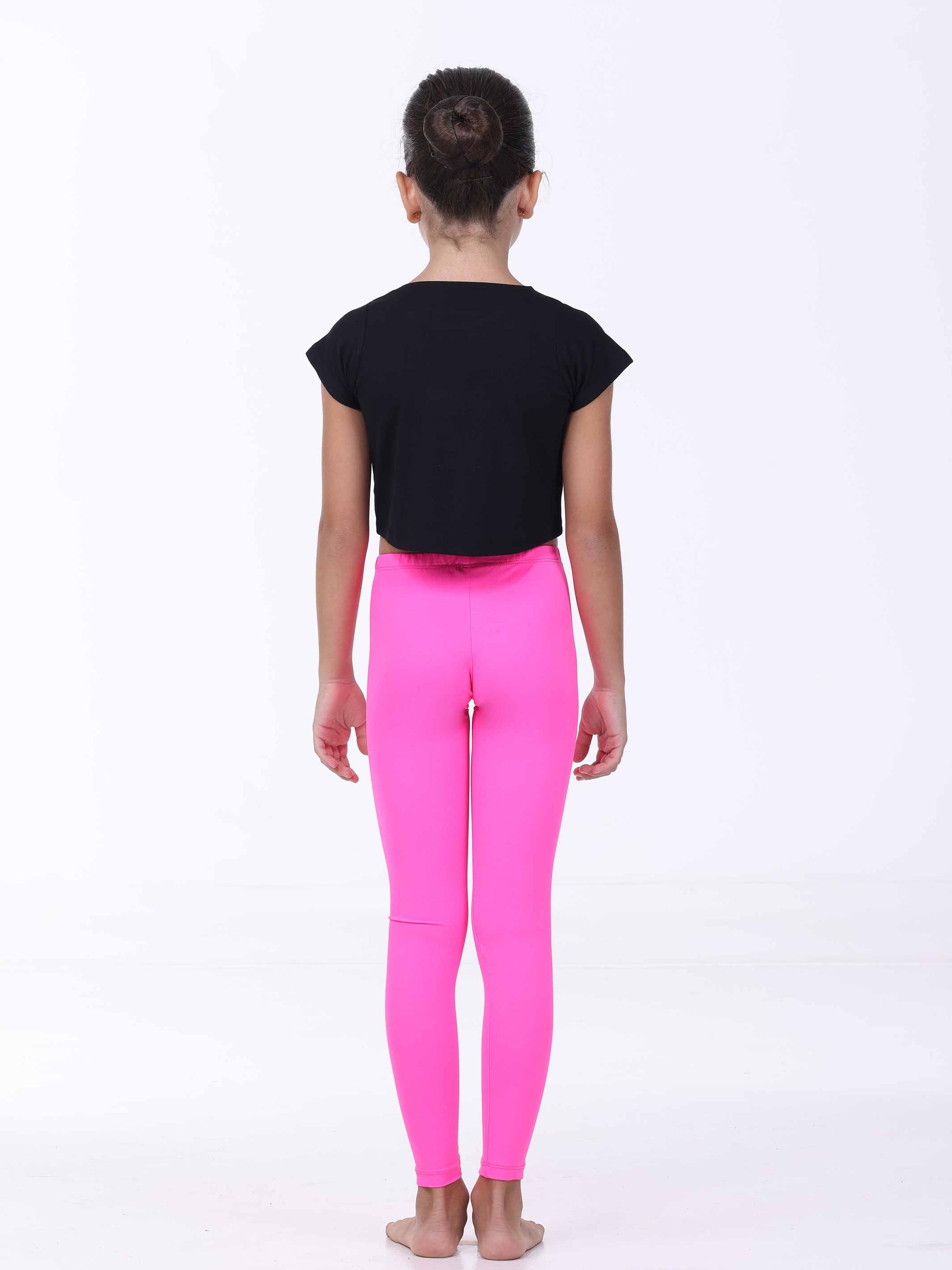 Person wearing a black top and bright pink leggings on a white background