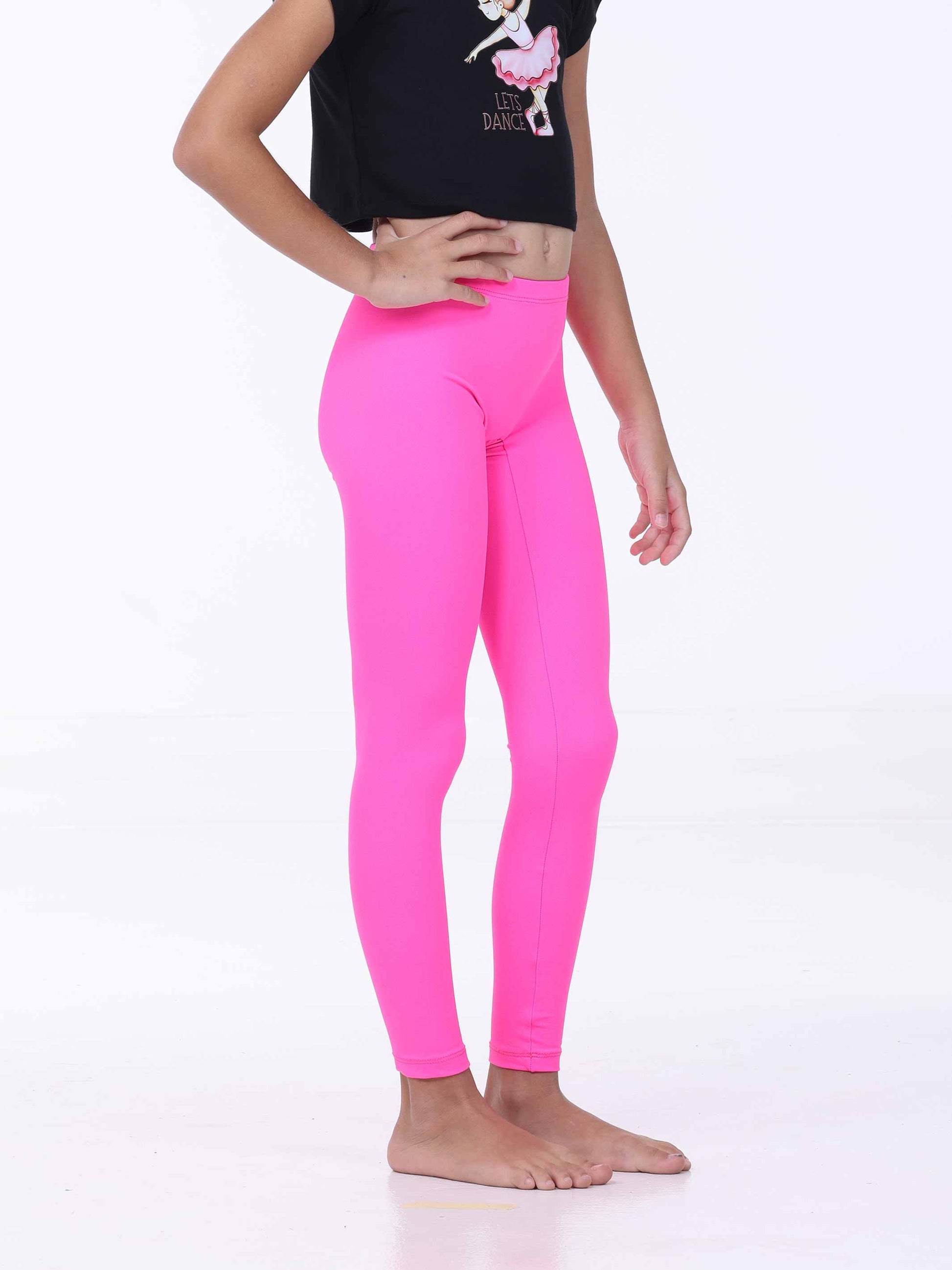 Person wearing bright pink leggings and a black crop top with a graphic design on a white background