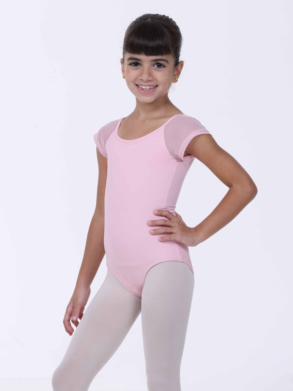 Young girl wearing a pink ballet leotard on a white background
