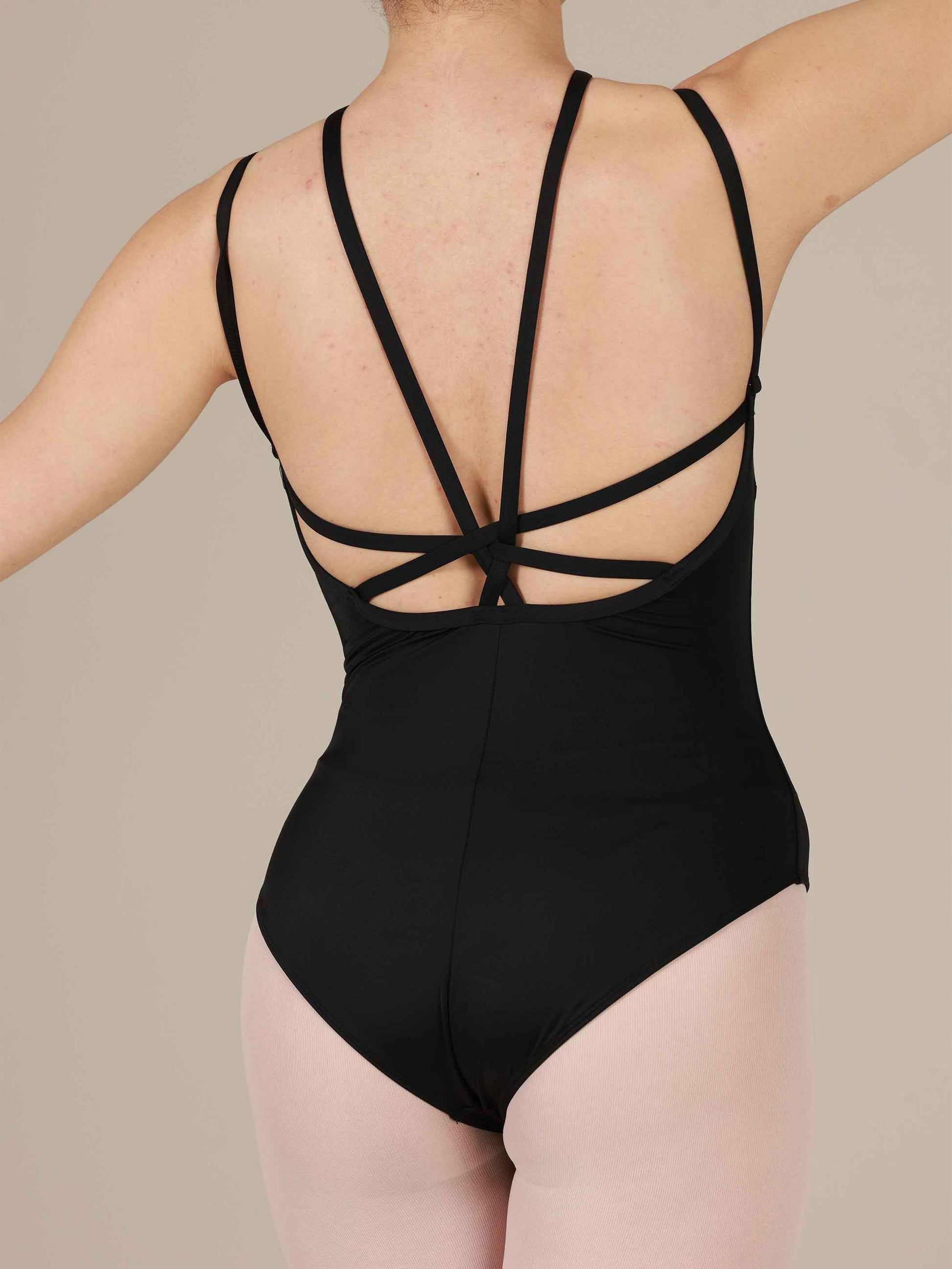 Black leotard with criss-cross straps on a neutral background