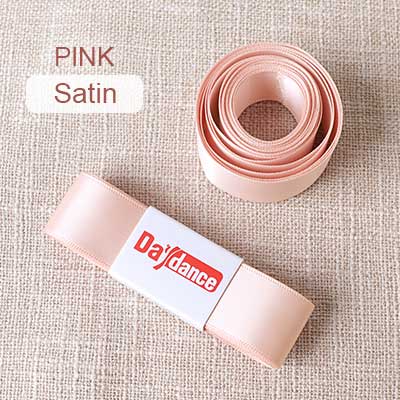 Pink satin ribbon with a spool on a beige fabric background