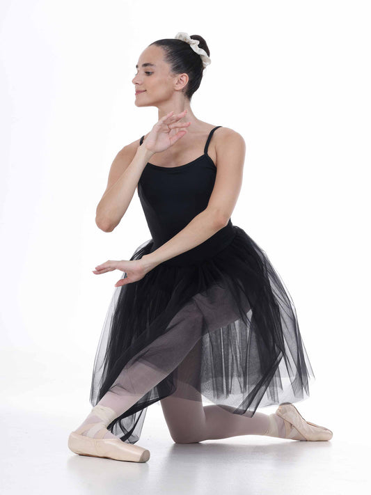 Ballerina in a black tutu dress posing on a white background