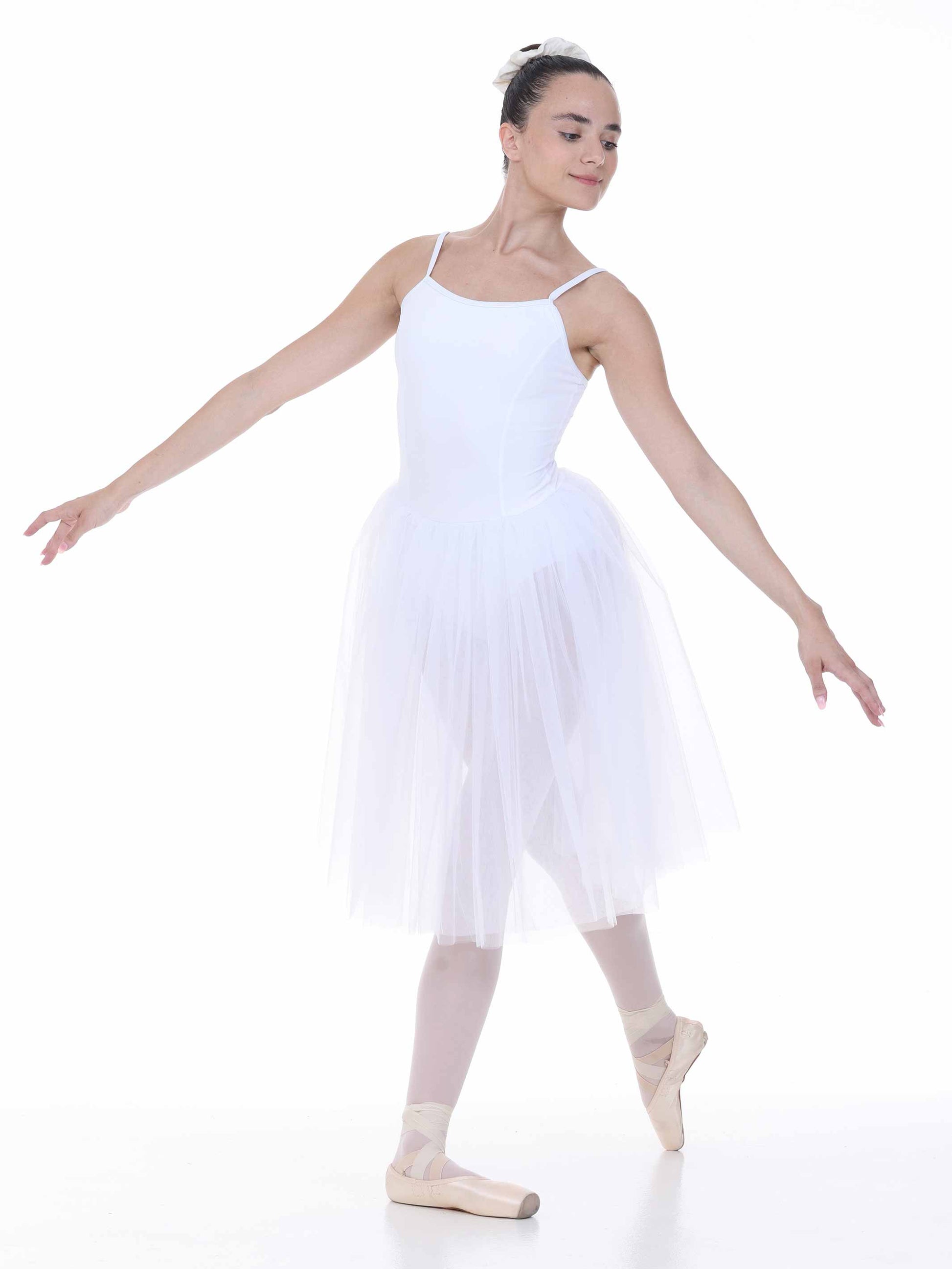 Ballerina in a white tutu dress and tights posing on a white background