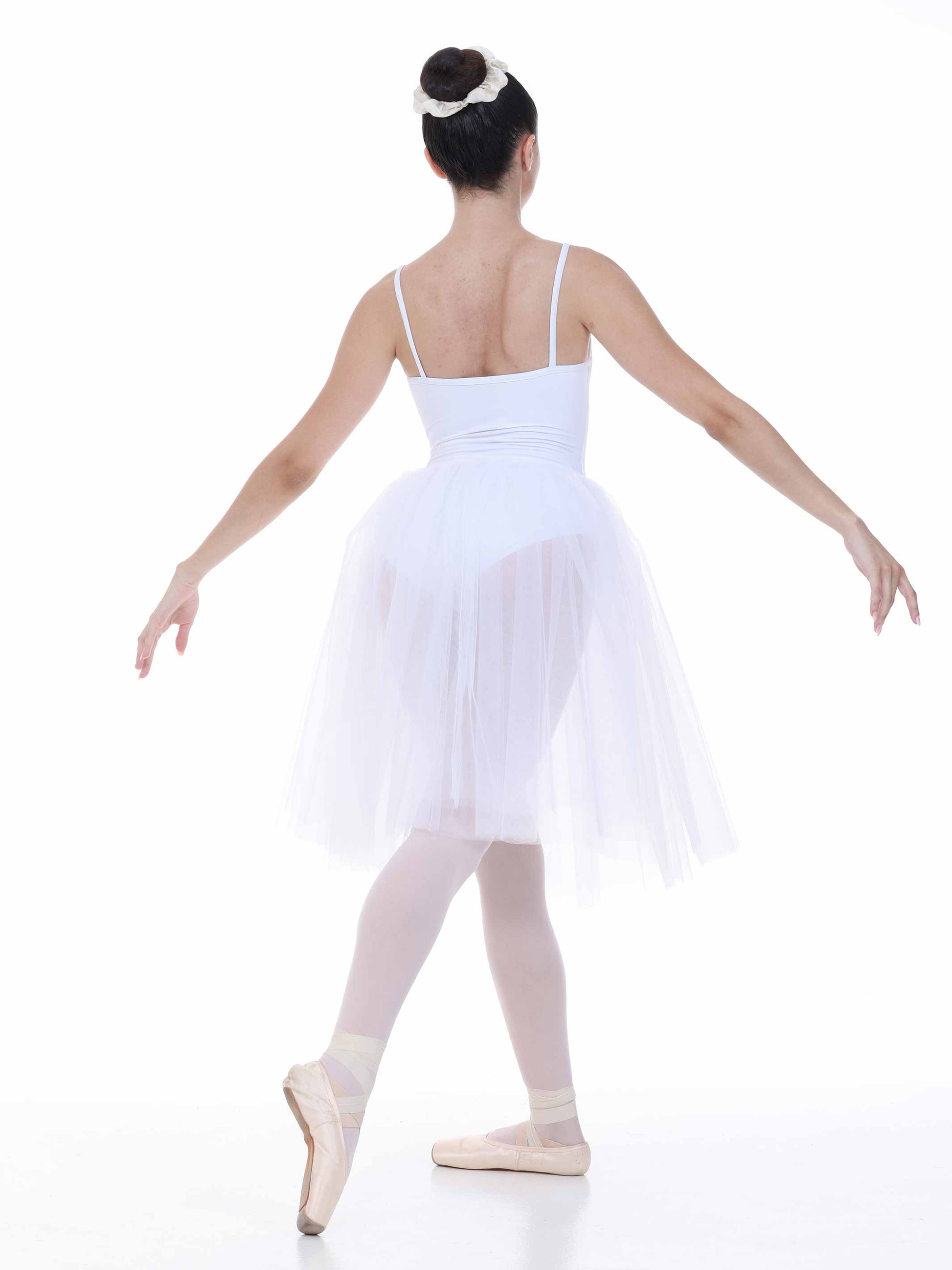 Ballerina in a white dress and tights on a white background