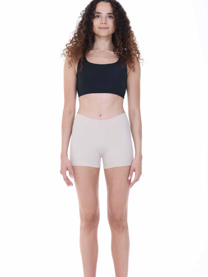 Woman wearing a black crop top and beige shorts on a white background