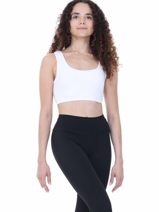 Woman wearing a white sports bra and black leggings on a white background